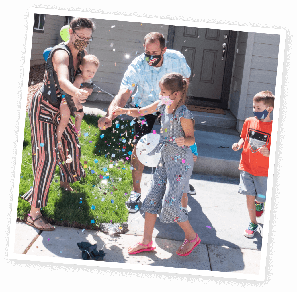 family celebrating in front of home